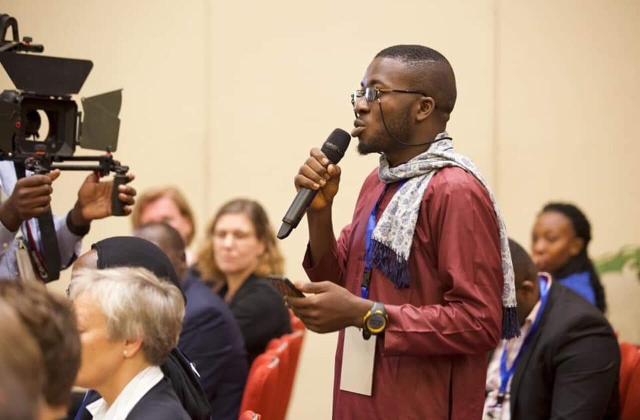 Femi Royal speaking from the floor at a conference